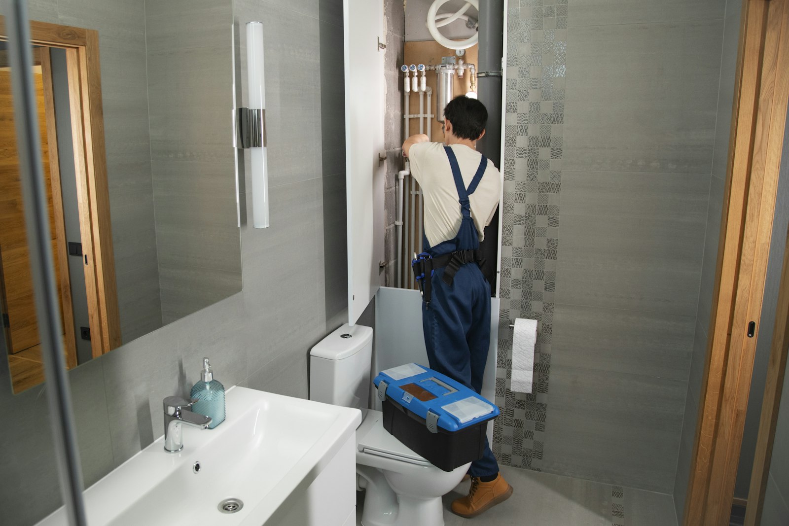 Plumber repairing pipework in a bathroom