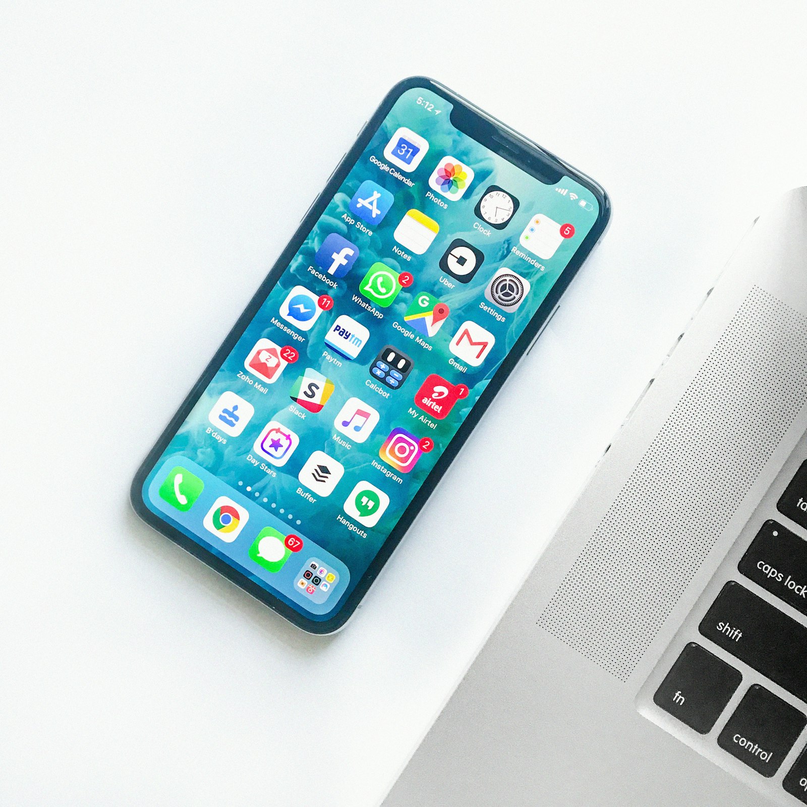 Smartphone beside a laptop on a work desk